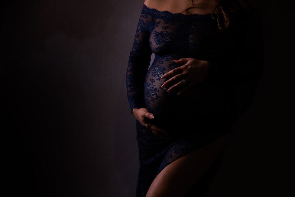 boudoir maternity session with sheer lace gown and emotional expression