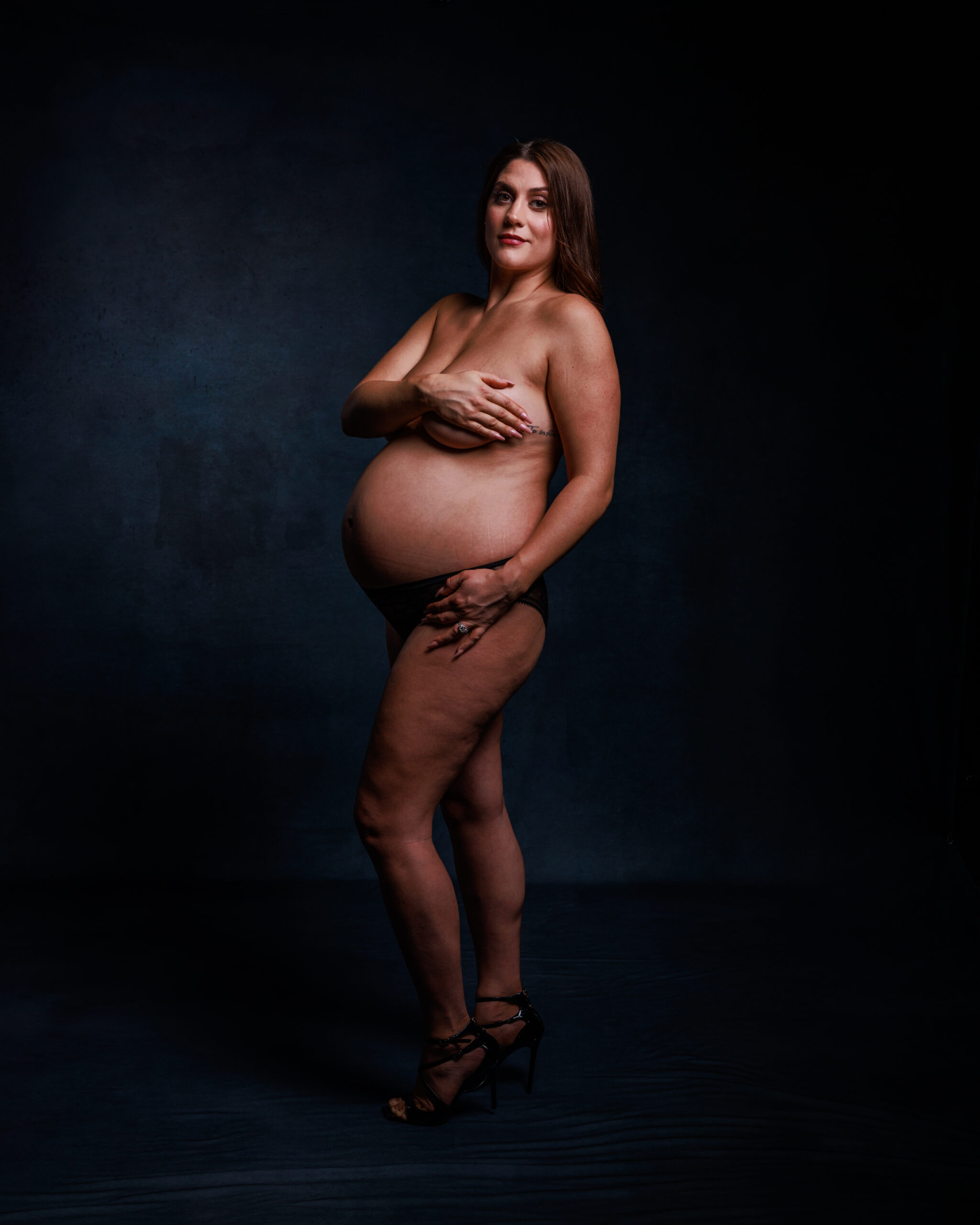 Full body motherhood portrait in studio with confident pose