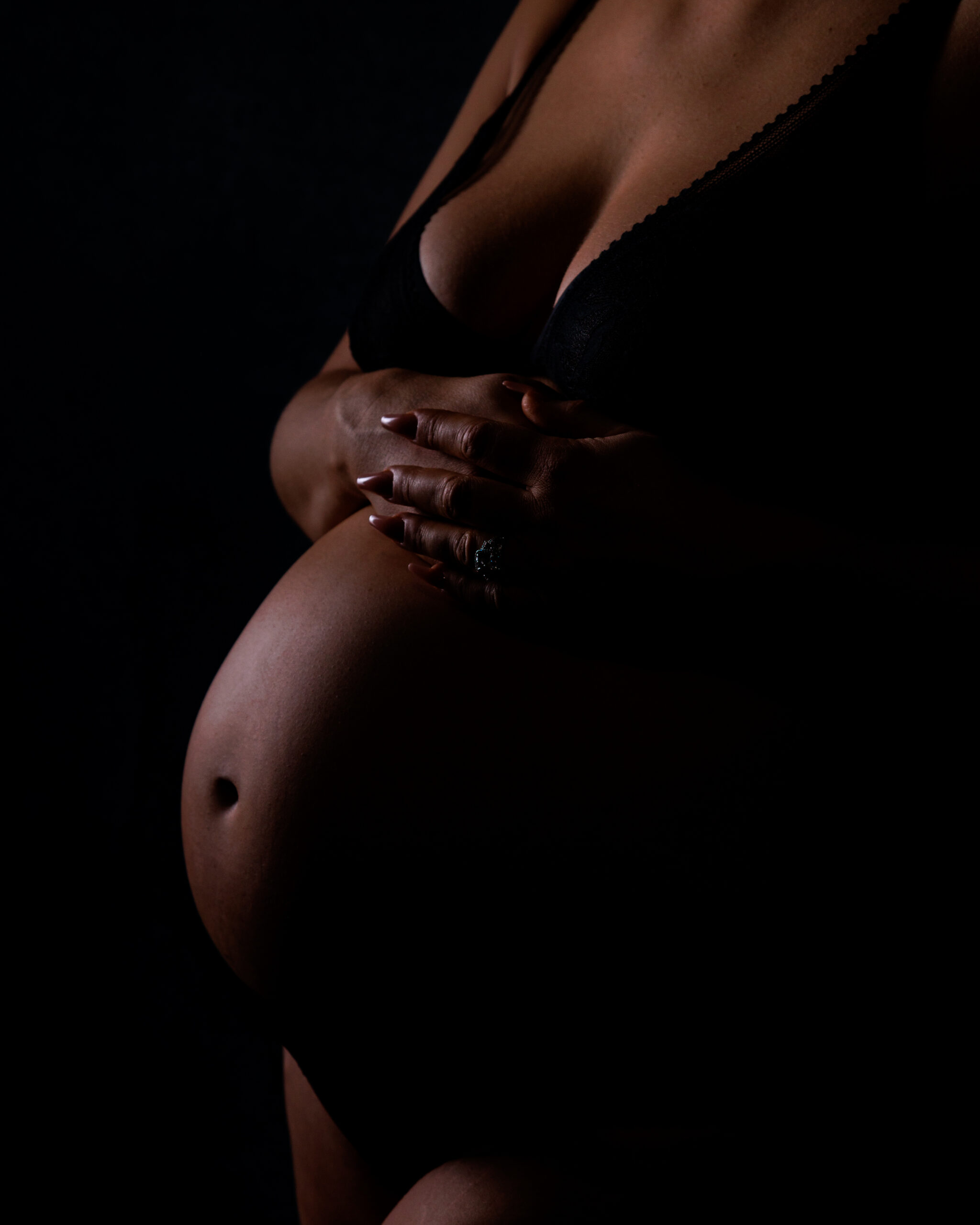 Intimate close up of pregnant belly with hands gently resting