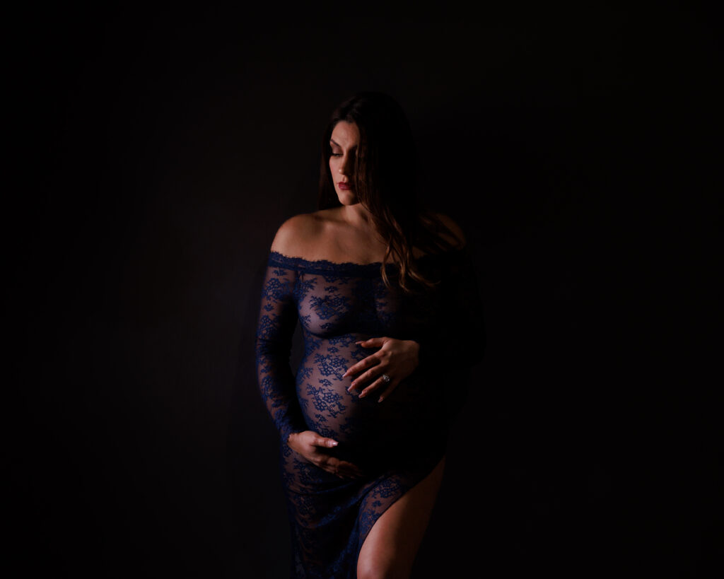 close up maternity detail of hands on belly with warm tones
