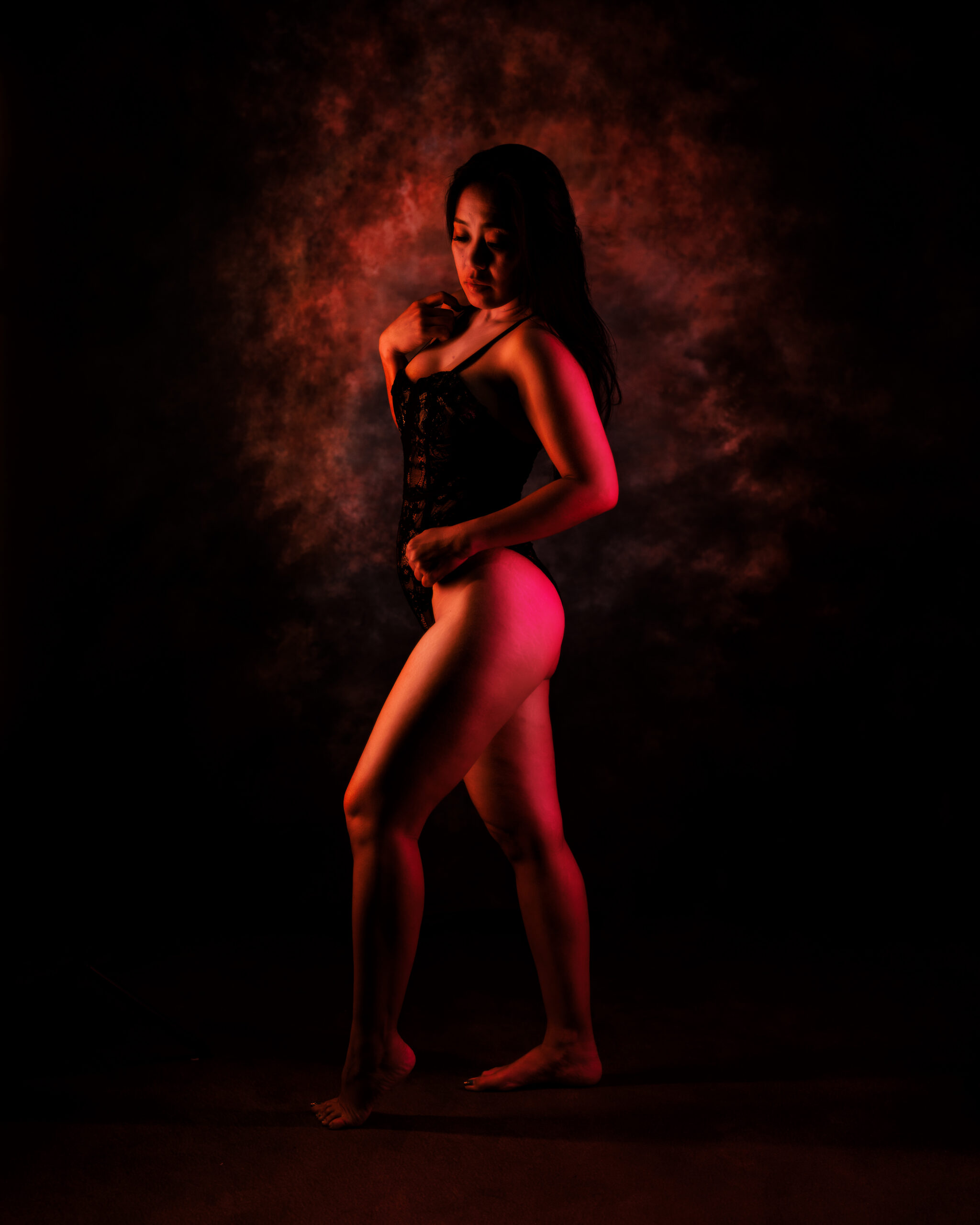 Indianapolis boudoir session with red lighting and confident standing pose