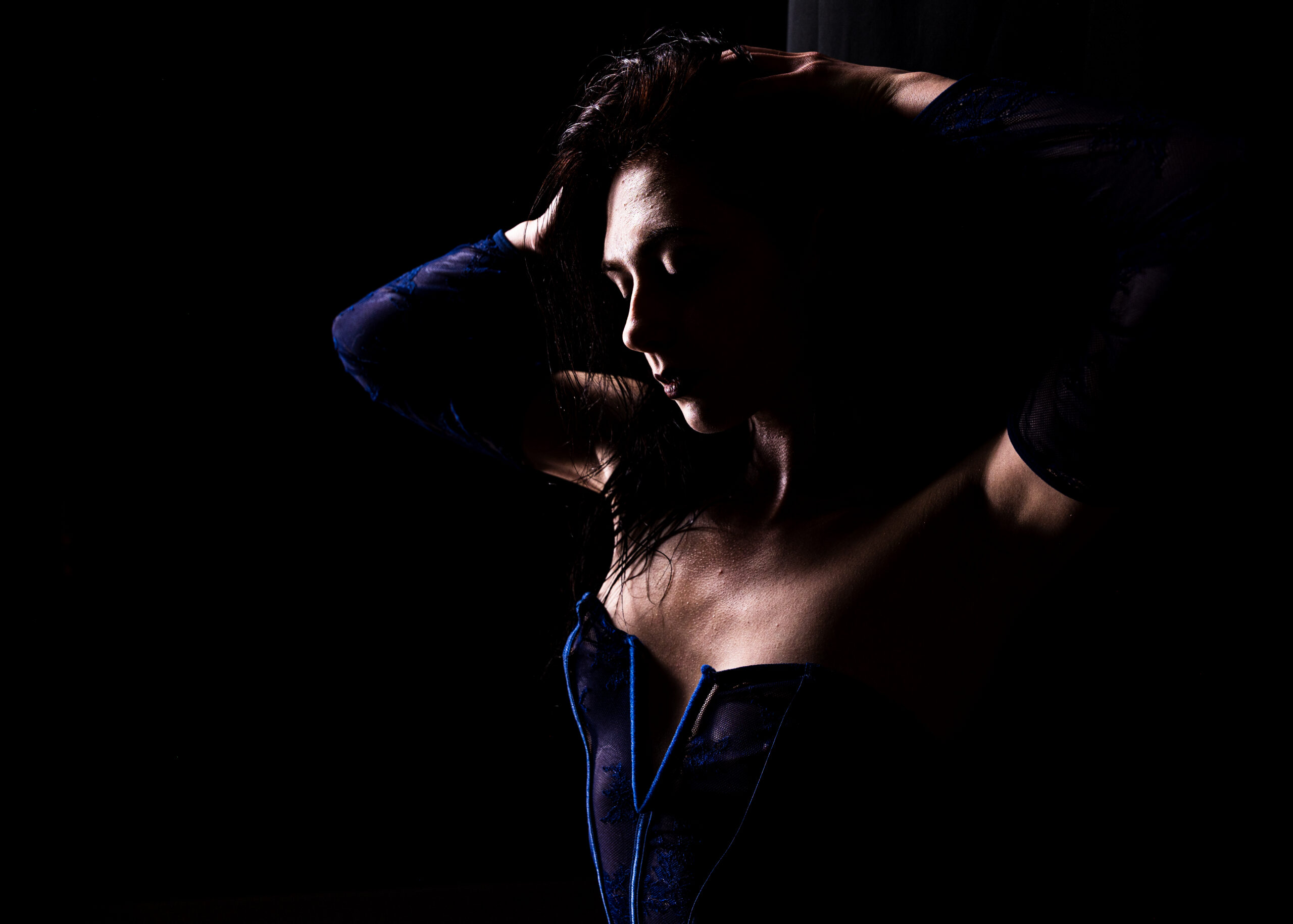 boudoir photography Indianapolis client in blue corset with moody studio lighting