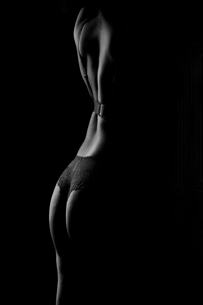 artistic studio boudoir pose with dramatic lighting and confident expression
