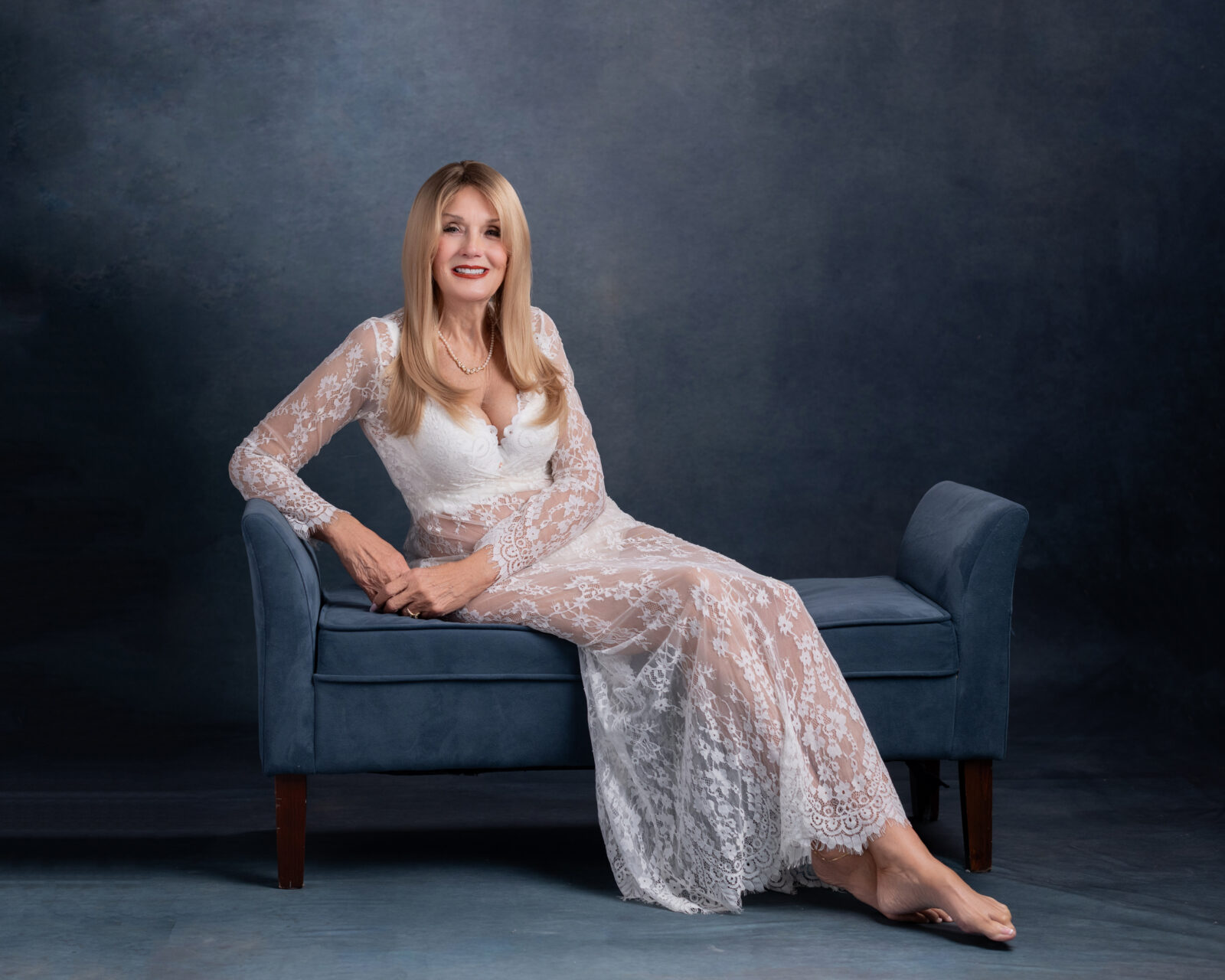 Woman in lace white on blue velvet bench