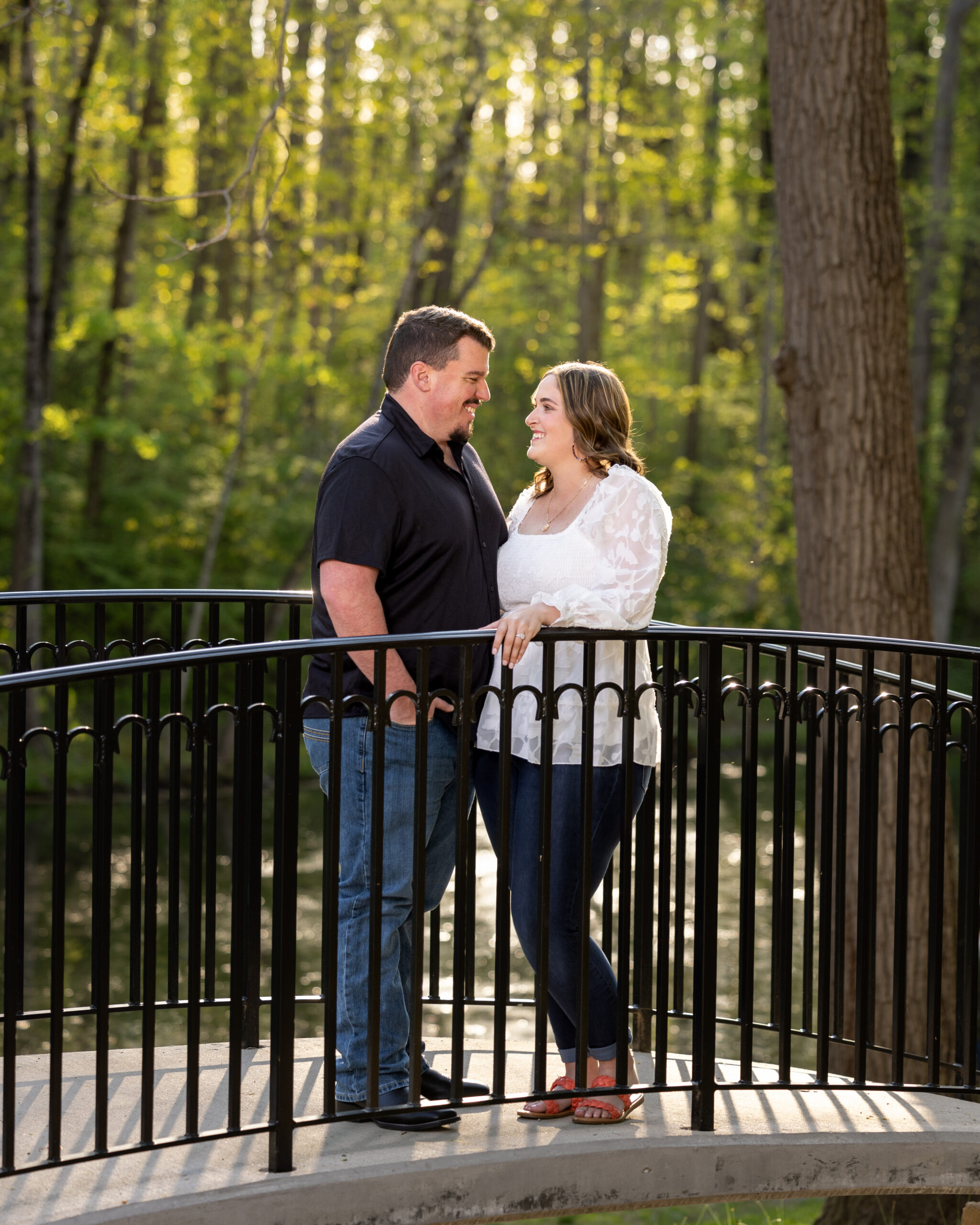 A couple sitting on a bridge at Holcomb Gardens on Butler University, a top family photo location in Indianapolis