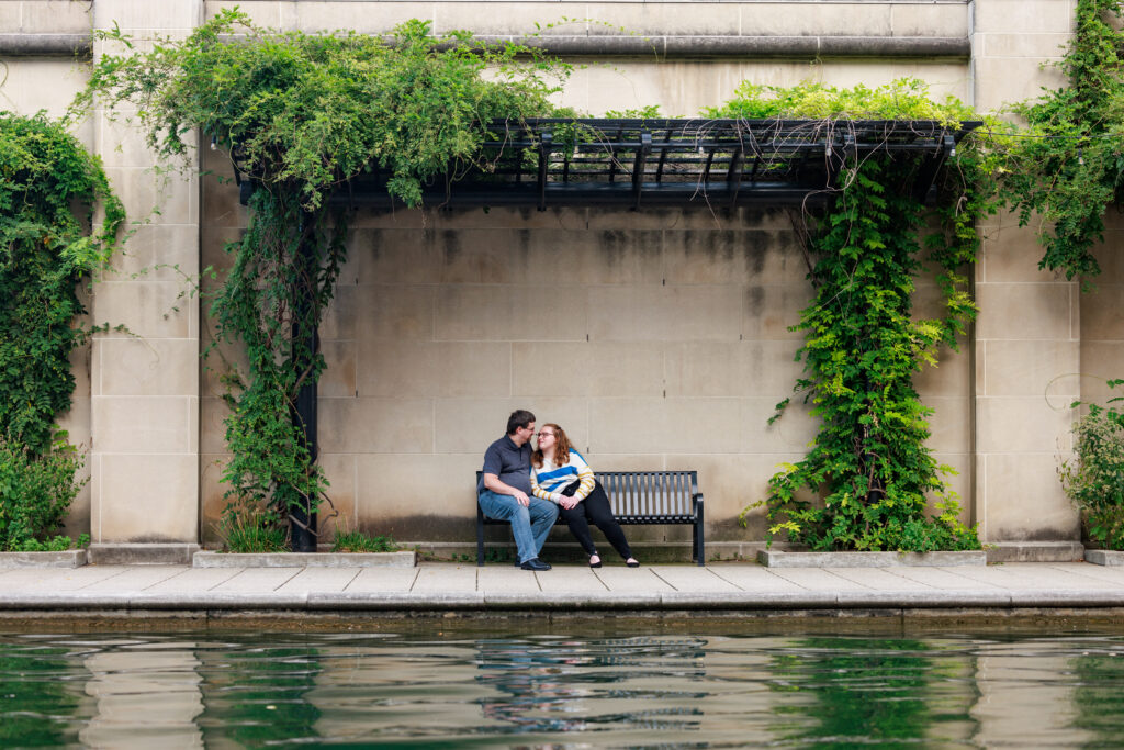 A couple poses on a bench on the Canal, a top family photo location in Indianapolis