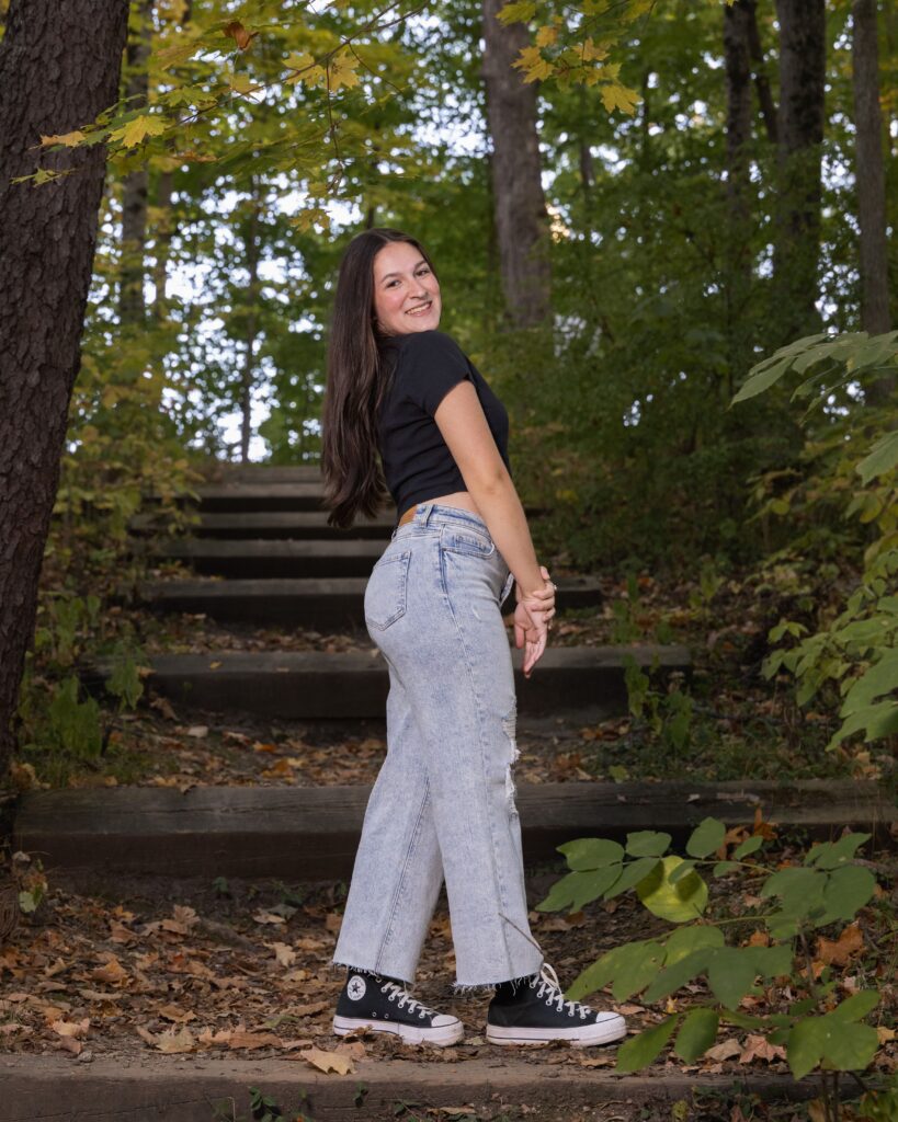 Indianapolis senior portrait session on wooden steps in a wooded park setting