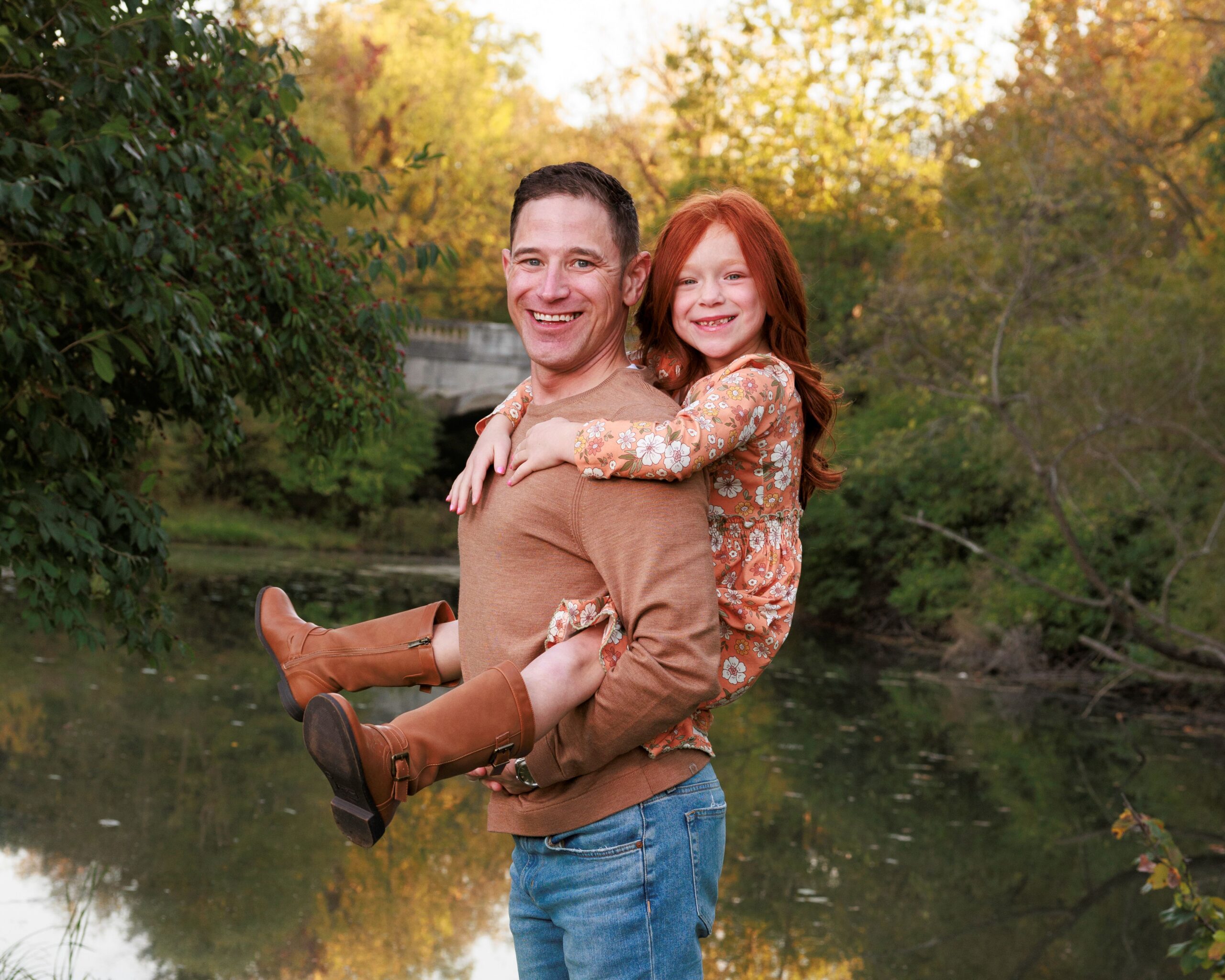 Father holds his daughter on his back during family photos at Fort Harrison State Park, a top family photo location in Indianapolis
