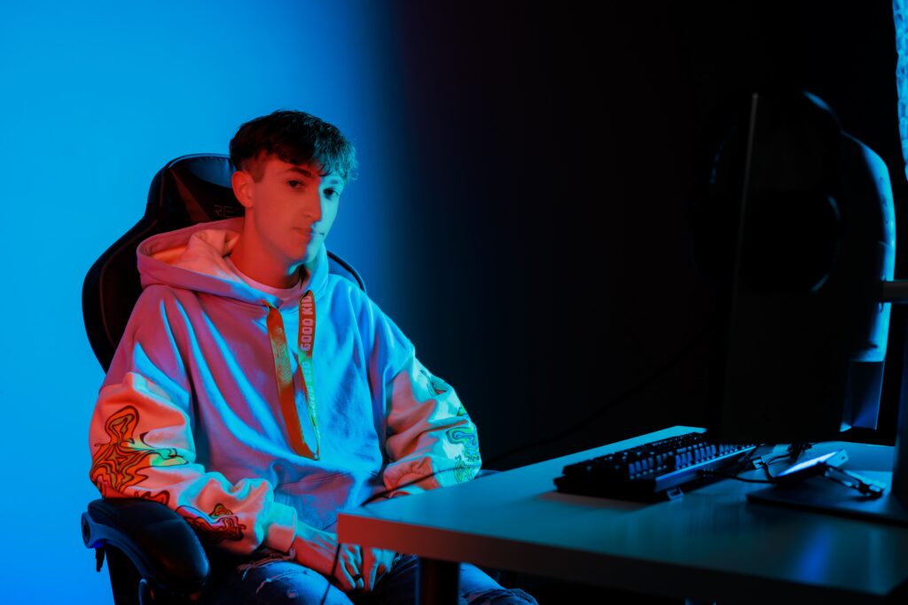 Senior photographer captures gamer portrait with dual-tone studio lighting and gaming setup