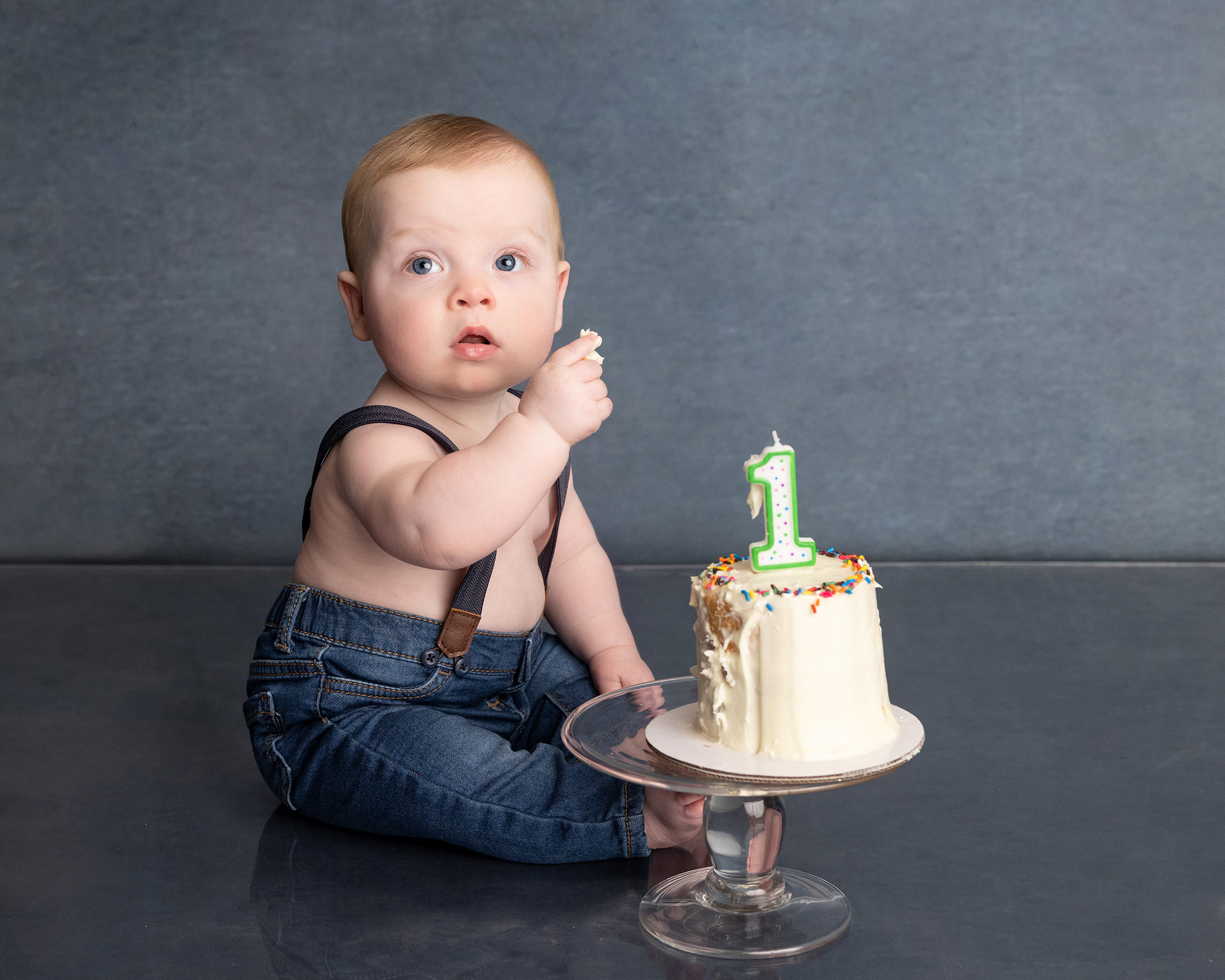 Baby eating birthday cake at the one year session of a grow with me photography package