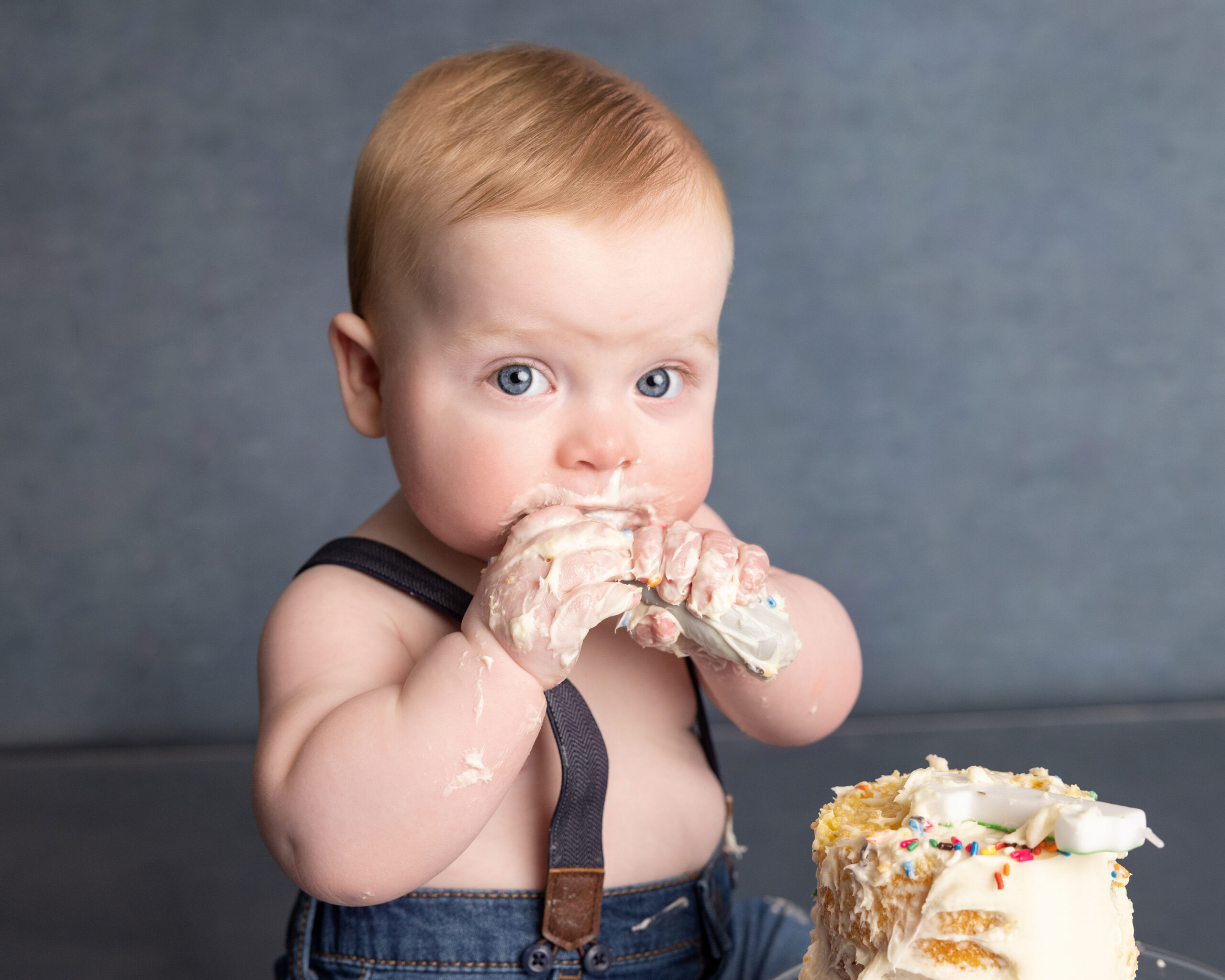 Baby eating birthday cake at the one year session of a grow with me photography package