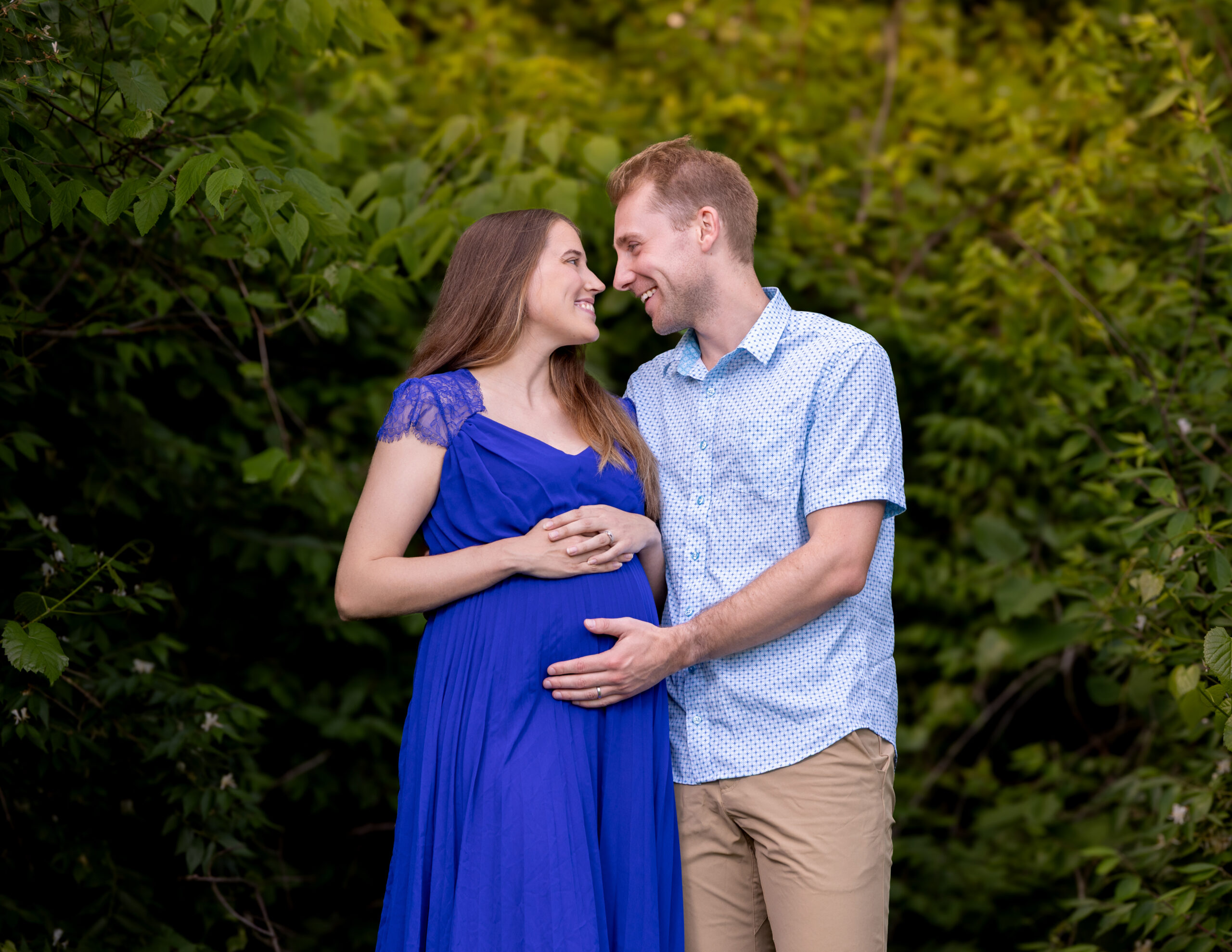 Couple embracing outdoors during their grow with me photography package maternity session