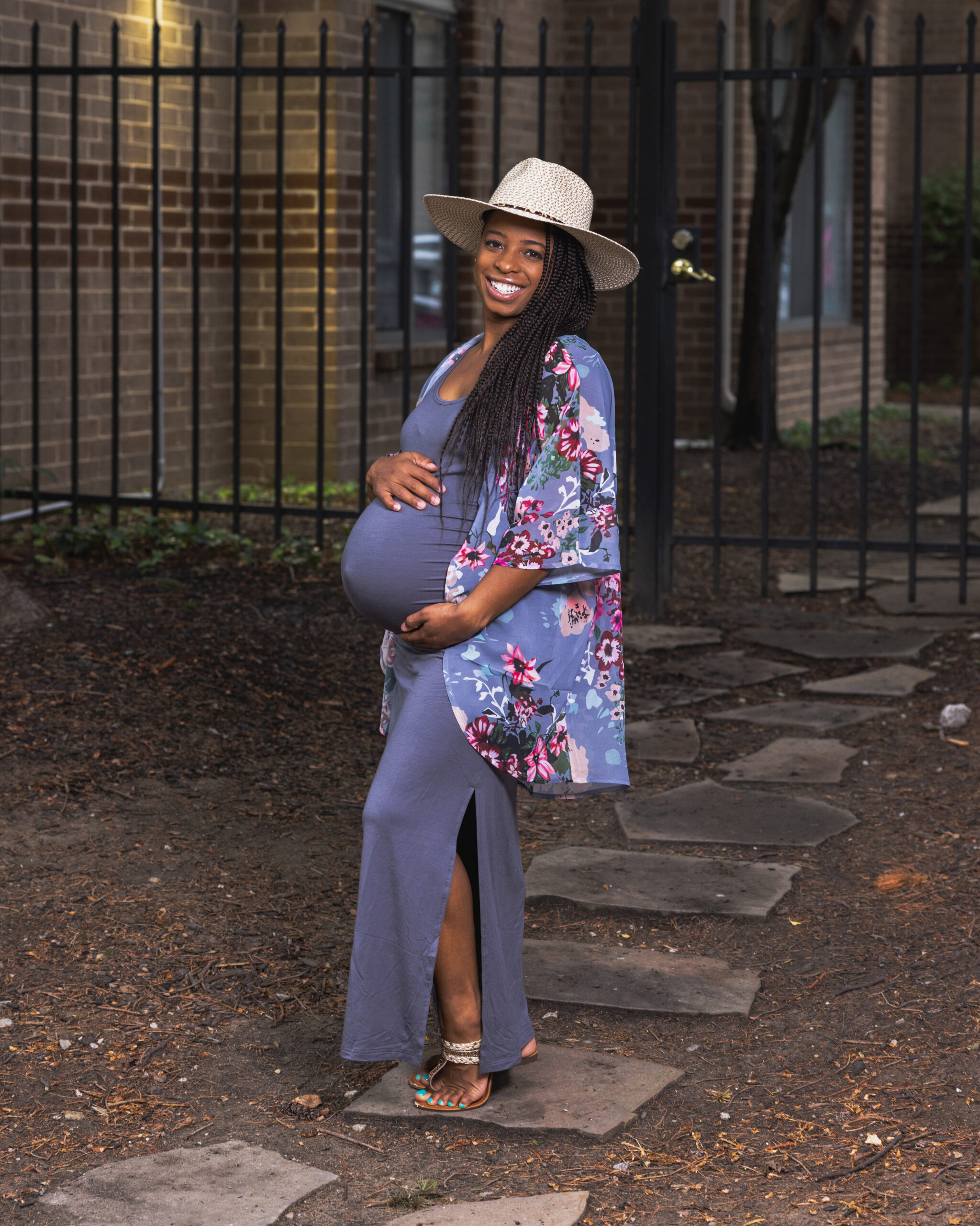 Pregnant woman smiling outdoors in sun hat, grow with me photography package maternity session
