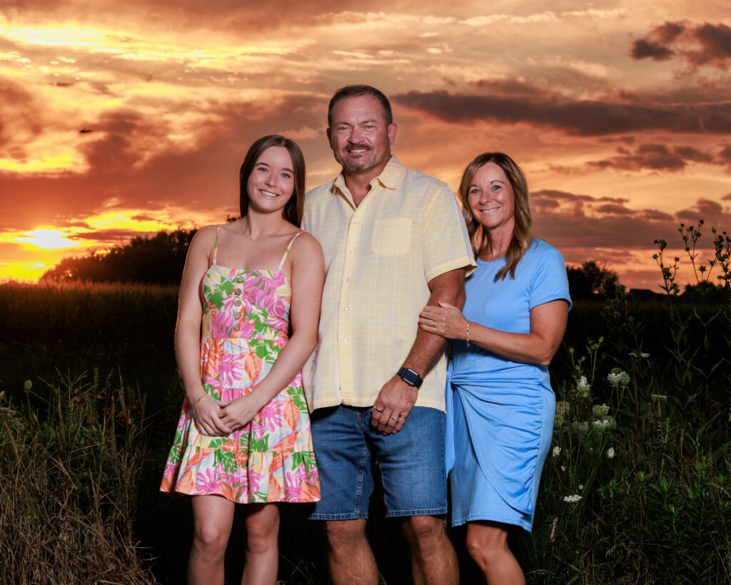 Three generations of family smiling together in a field during a golden Indianapolis sunset fall family photos indianapolis