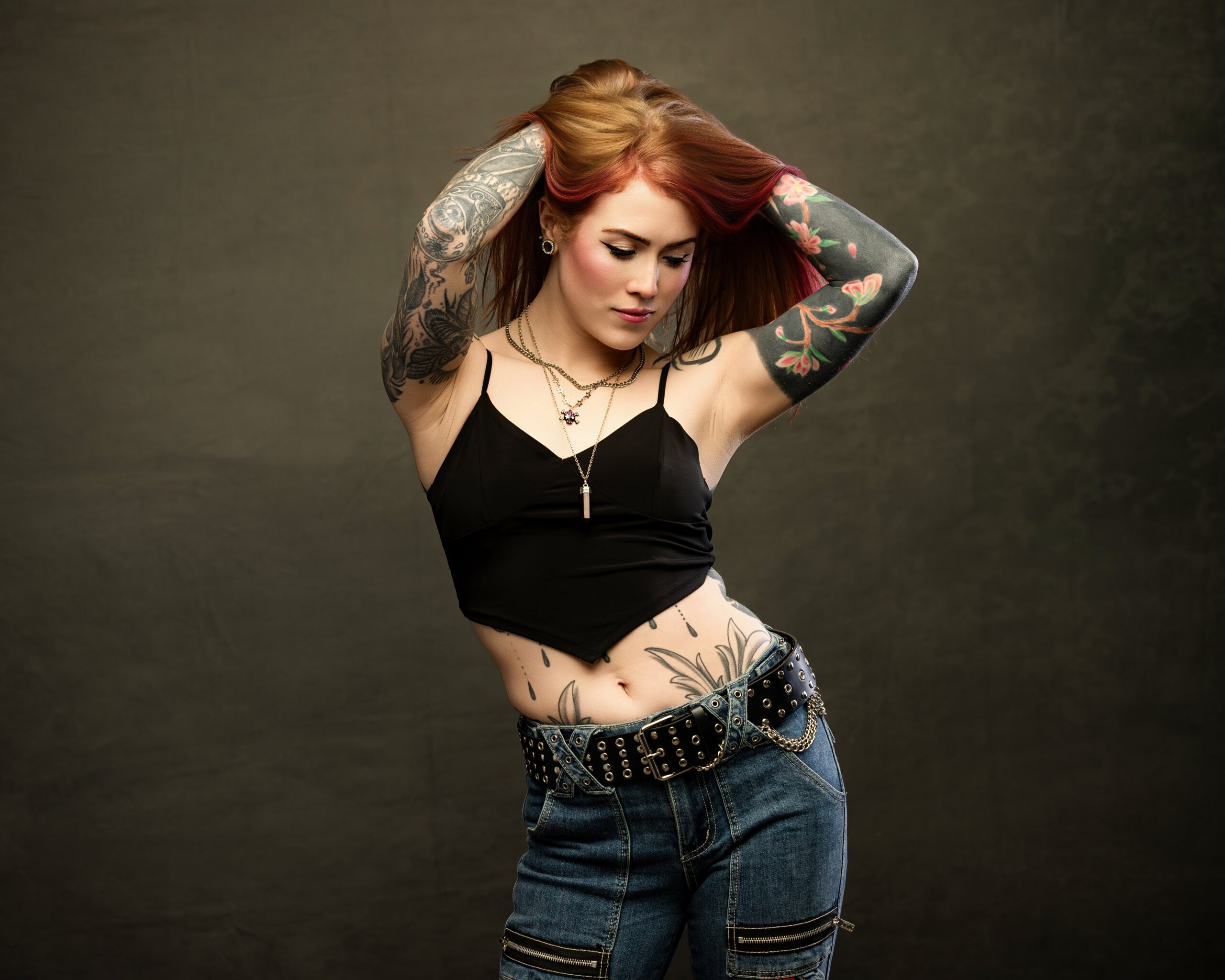 Deep, moody studio backdrop with dramatic directional lighting wearing a black top boudoir photoshoot outfits