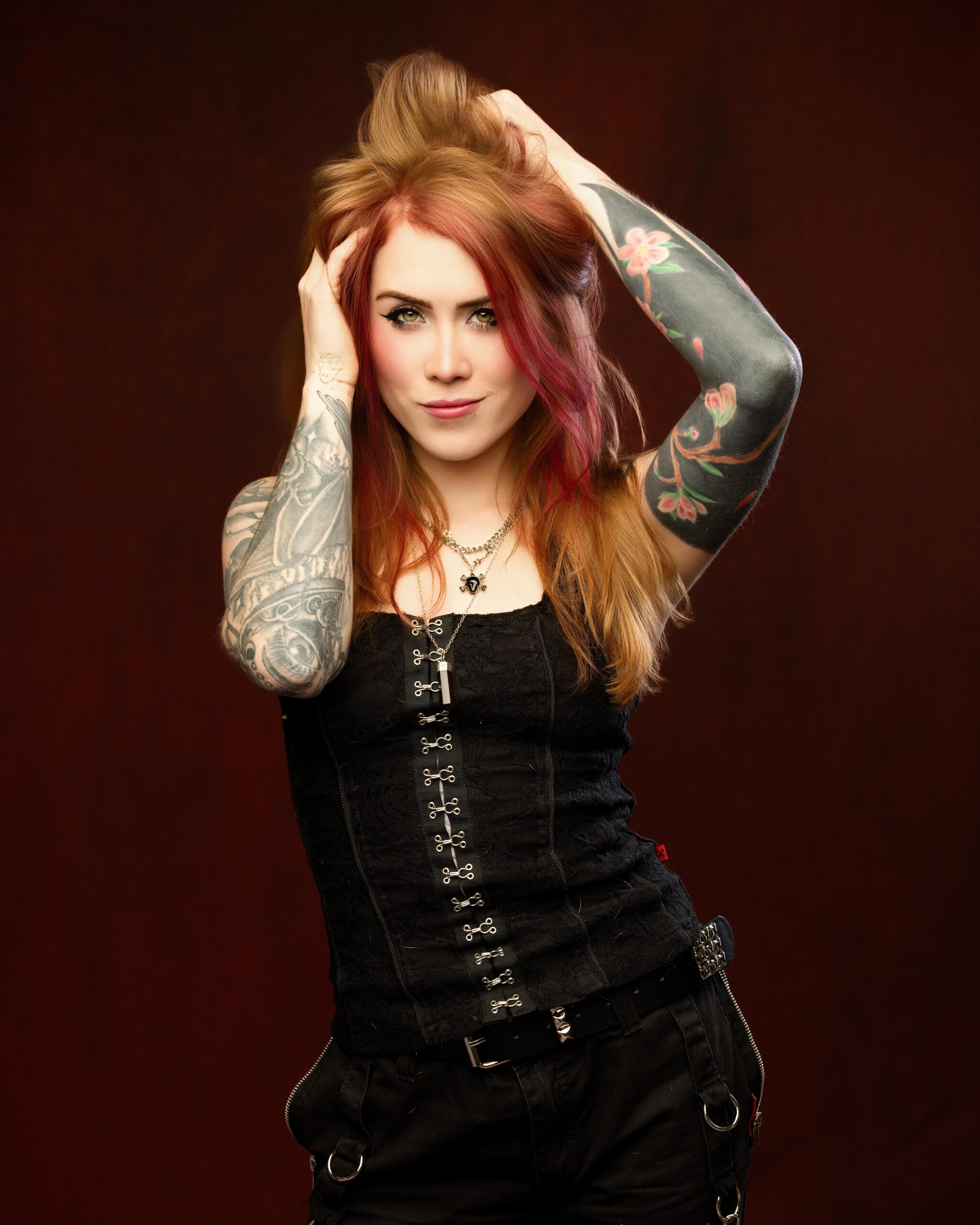 Rich, moody lighting against a deep maroon studio backdrop
