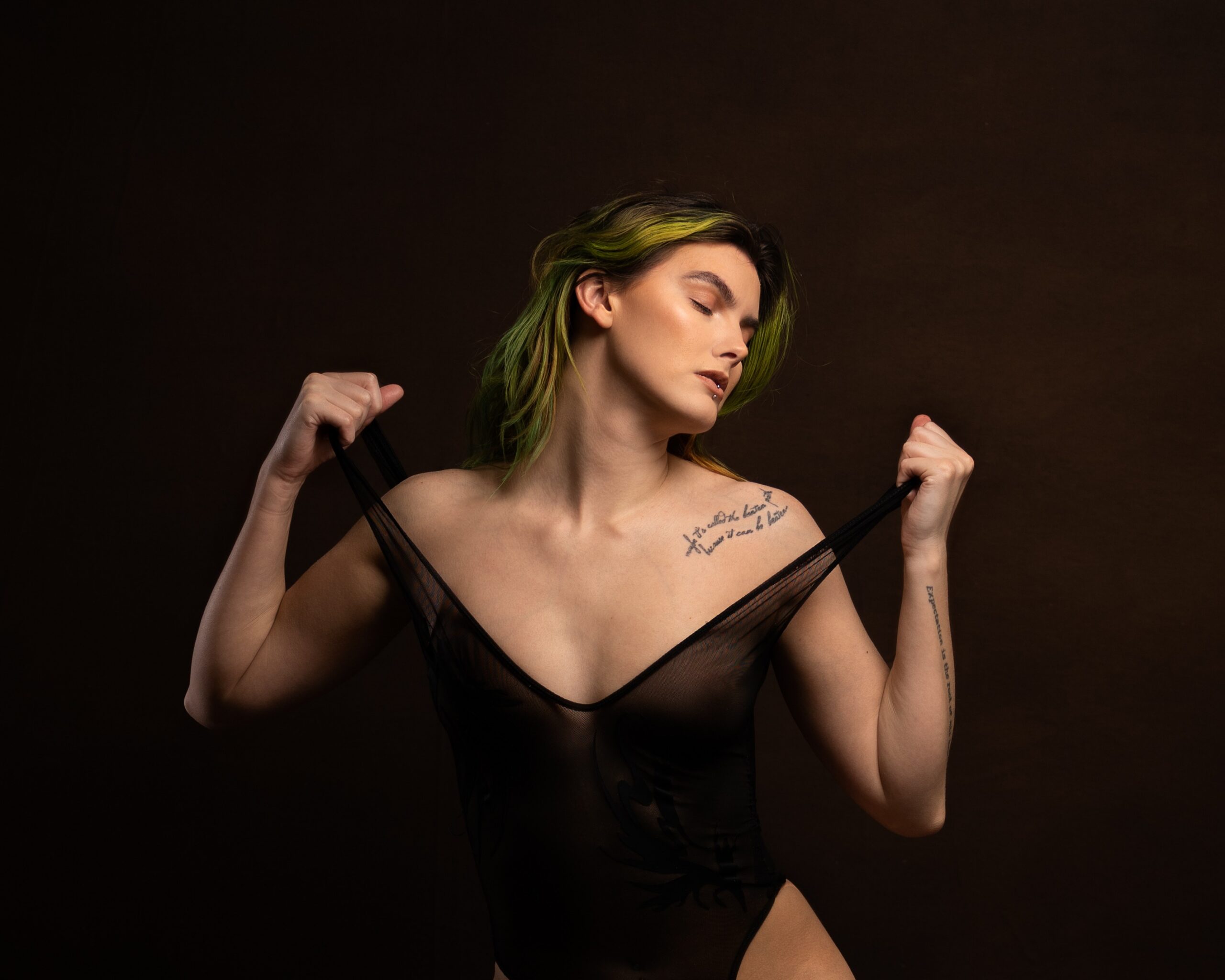 Warm, low copper-toned light fills a dark studio backdrop for a women empowerment photoshoot