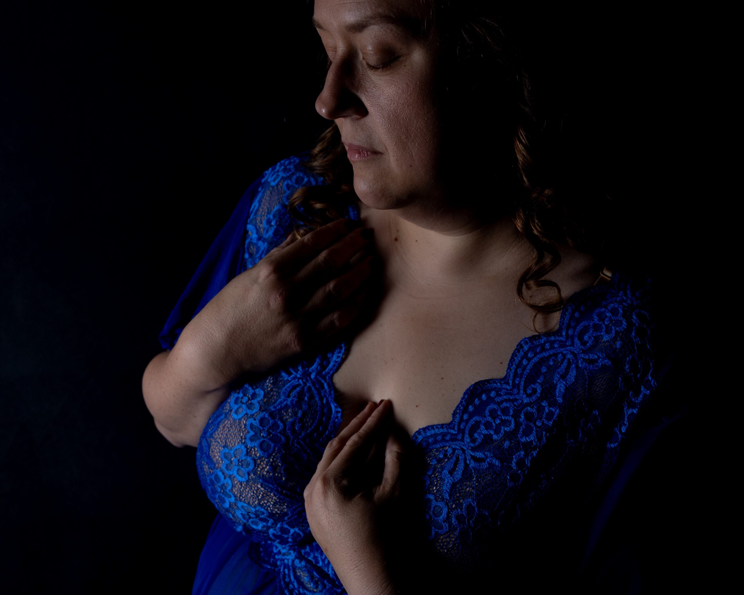 Close, candlelit detail in moody low light with soft shadow across deep blue tones
