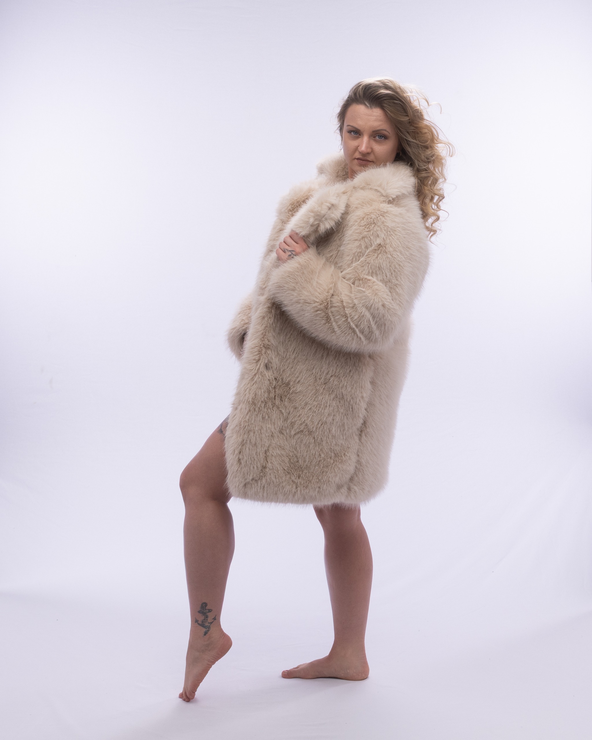 Bright studio lighting against a clean white backdrop, full-length boudoir studio setting