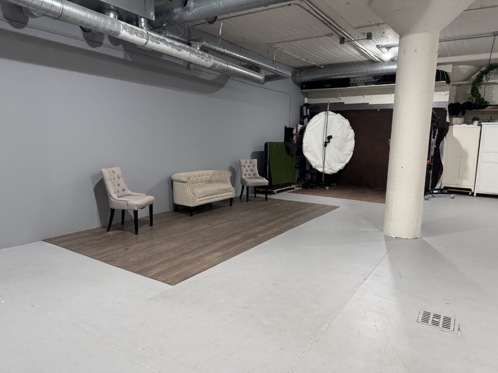 Empty studio space with seating and lighting equipment, where our boudoir photo shoot ideas come to life at Embrace Boudoir